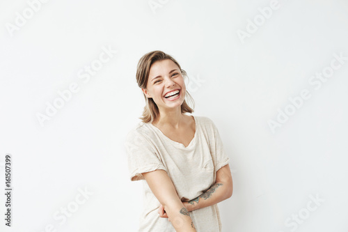 Cheerful happy young beautiful girl looking at camera smiling laughing over white background.