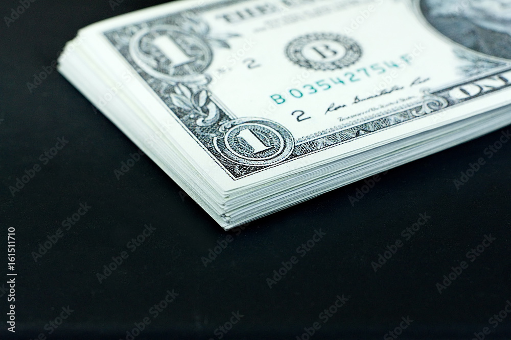 US dollars banknote stack on black background US dollars banknote stack on black background