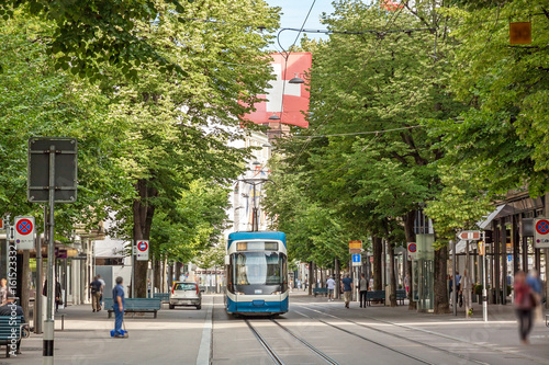 Zurich shopping street Bahnhofstrasse with tram and swiss flag