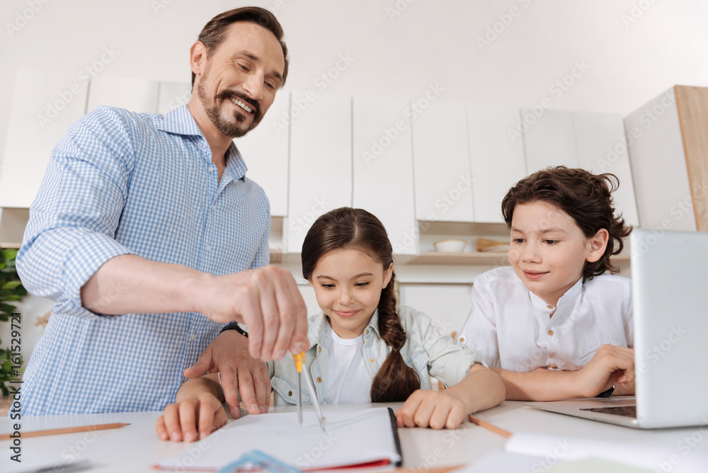 Curious children watching their father using compass Curious children watching their father using compass