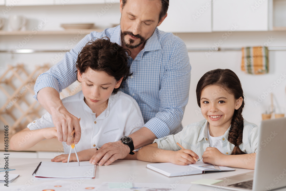 Caring father showing his son how to use a compass Caring father showing his son how to use a compass