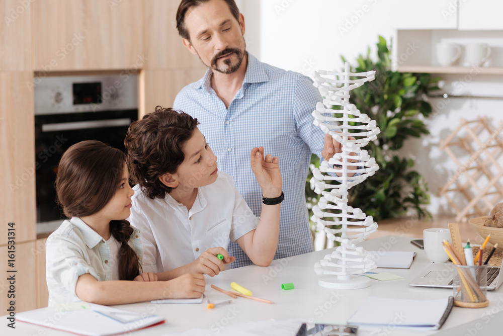 Young father explaining the notion of DNA to his children Young father explaining the notion of DNA to his children