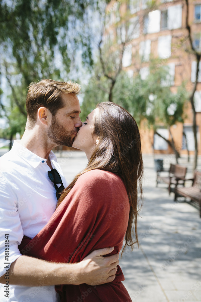 Happy couple kissing and hugging in the street Happy couple kissing and hugging in the street