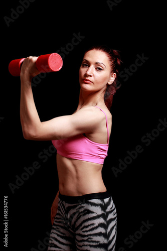 Fitness sporty woman with dumbbell show biceps on a black isolation background.