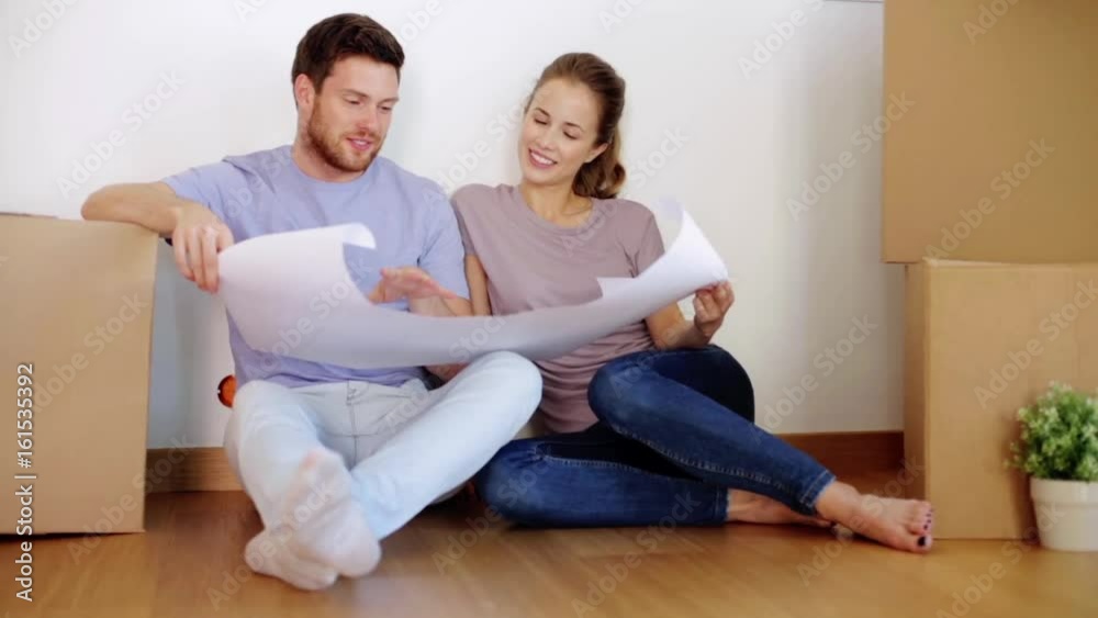 happy couple with blueprint at new home happy couple with blueprint at new home