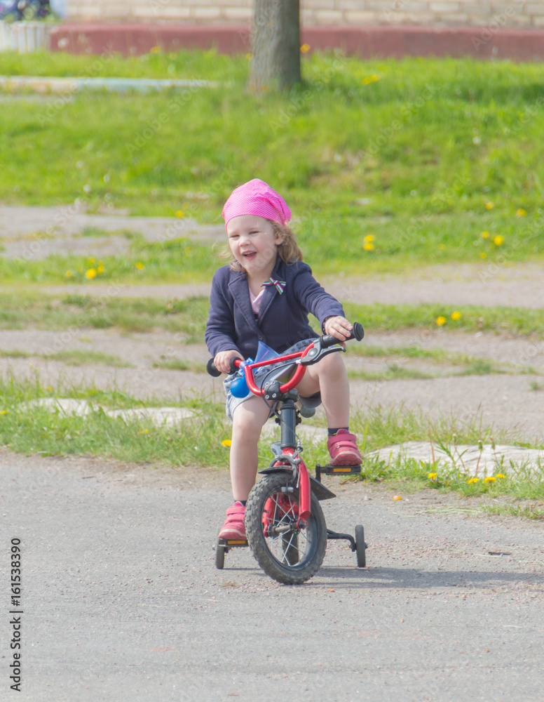 on the Playground the child rides the girl on the bike. on the Playground the child rides the girl on the bike.