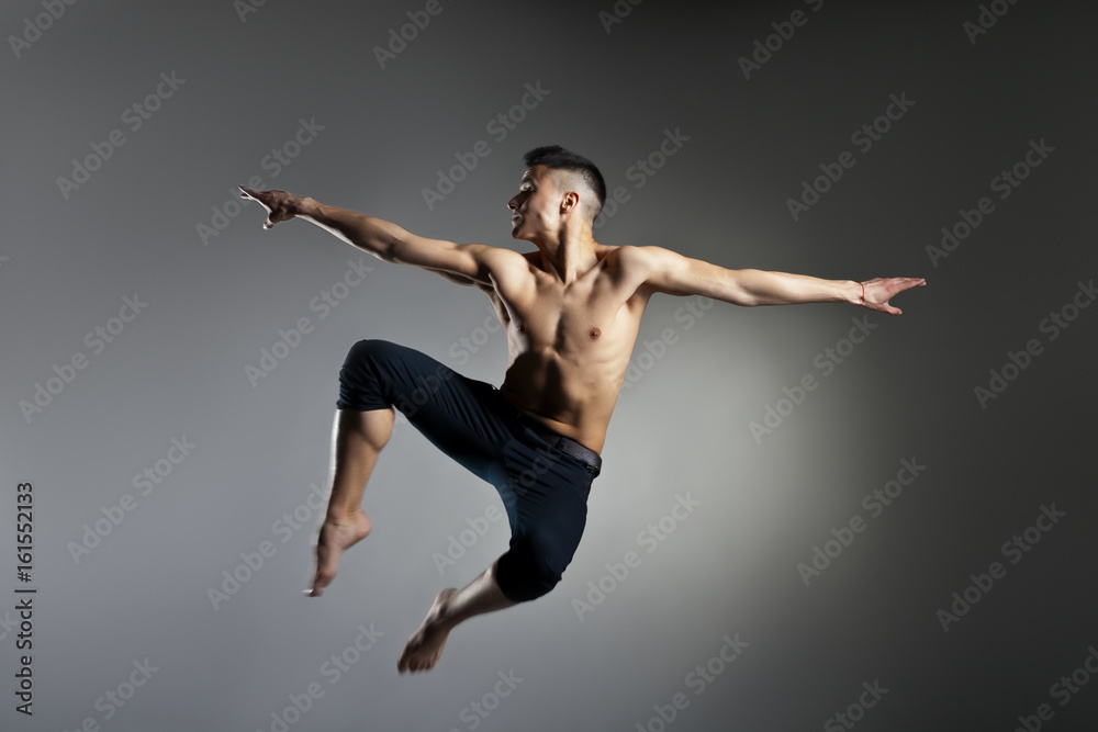 Caucasian man gymnastic leap posture on grey background