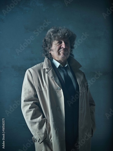 The senior man as detective or boss of mafia on gray studio background