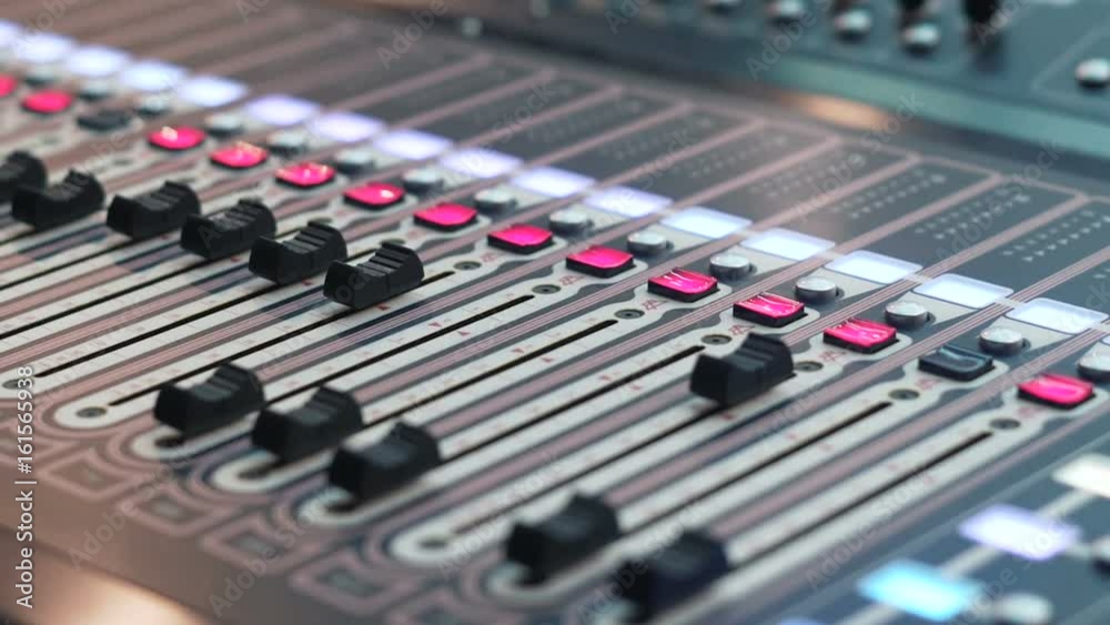 studio console with lots of buttons and displays in the hardware block studio channel. Mixing board with automation. Close up of a digital audio workstation with an audio console. Digital sound mixer studio console with lots of buttons and displays in the hardware block studio channel. Mixing board with automation. Close up of a digital audio workstation with an audio console. Digital sound mixer