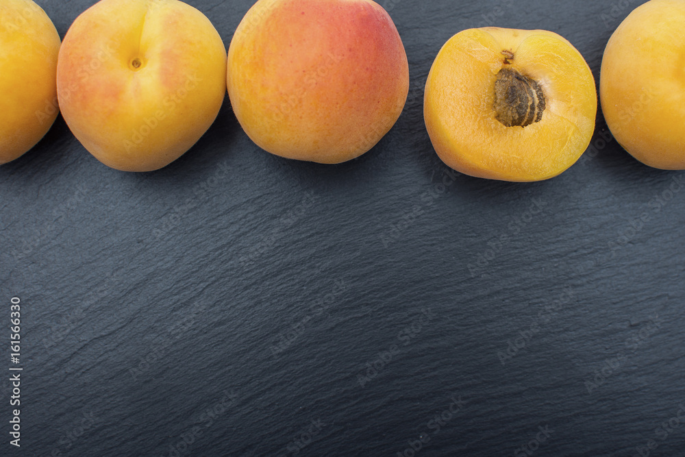 Ripe apricot on black background of slate or stone Ripe apricot on black background of slate or stone