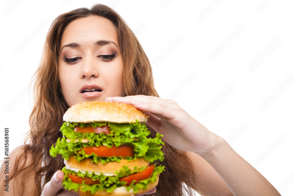 Happy Young Woman Eating big yummy Burger isolated on white background Happy Young Woman Eating big yummy Burger isolated on white background