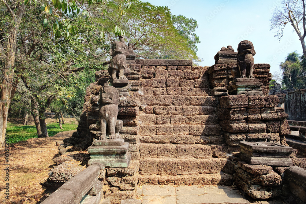 Fototapeta premium Lions in the foreground guarding Preah Khan Temple in Angkor Complex, Siem Reap, Cambodia. Ancient Khmer architecture and famous Cambodian landmark, World Heritage.