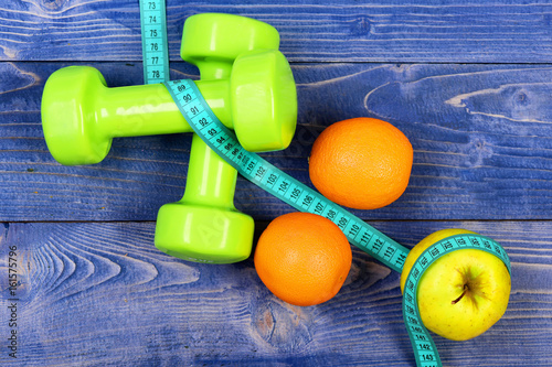 aerobic concept, dumbbells weight with measuring tape, fruit