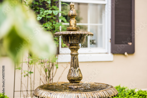 Vintage aged European fountain in Frederick, Maryland in downtown during summer with water droplets