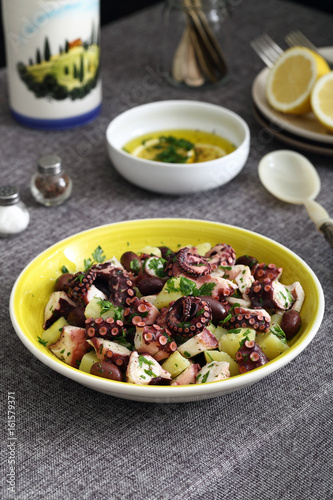 insalata di polpo con patate e olive su sfondo tavolo di cucina