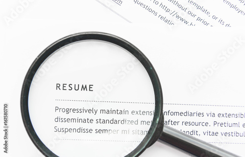 The magnifying glass shines on the resume for searching candidate concept