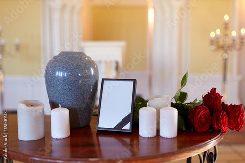 photo frame, cremation urn and candles in church