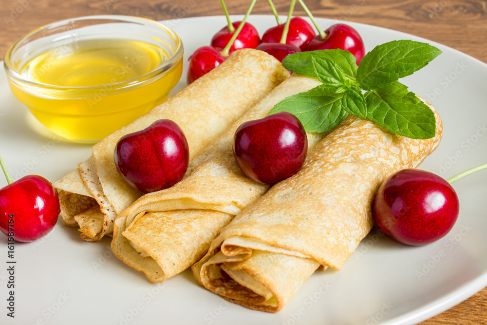 Whole gran pancakes with honey, mint and cherries. Useful breakfast. Whole gran pancakes with honey, mint and cherries. Useful breakfast.