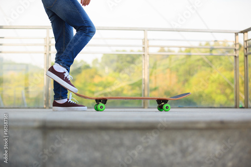 Skateboarder legs skateboarding at city