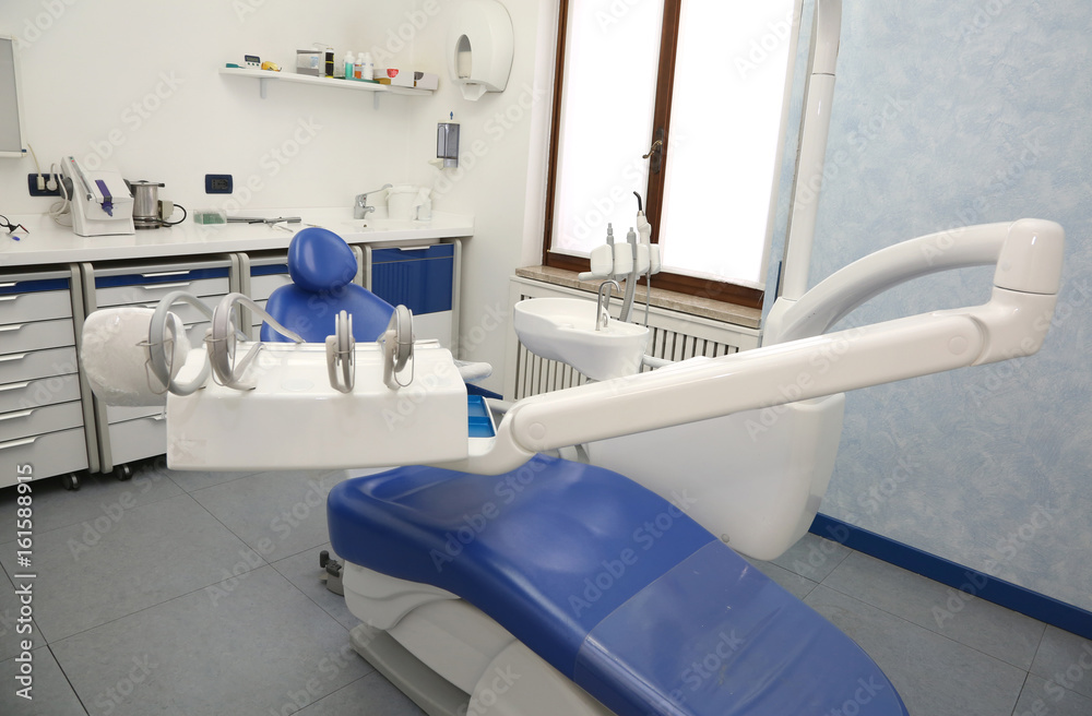 dental clinic with and chair without people and a big wall monit