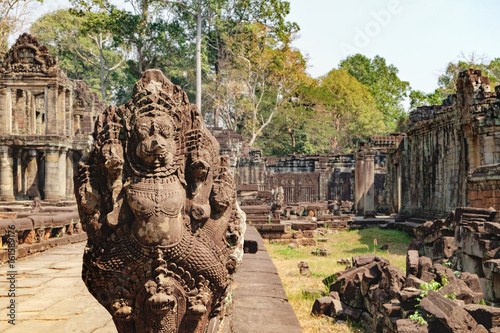 Naga serpent cobra king Vasuki in the foreground guarding Preah Khan Temple in Angkor Complex, Siem Reap, Cambodia. Ancient Khmer architecture and famous Cambodian landmark, World Heritage. photo