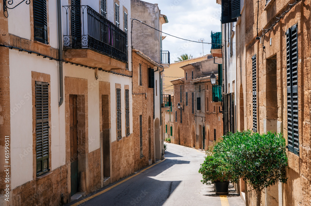 Narrow street of historical town part of Alcudia with its traditional house and architecture