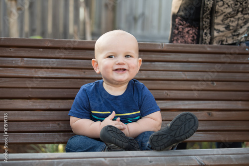 Baby Boy Sitting on Garden Bench