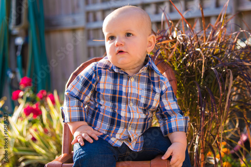 Baby Boy in Plaid Shirt Sitting in Backyard Garden