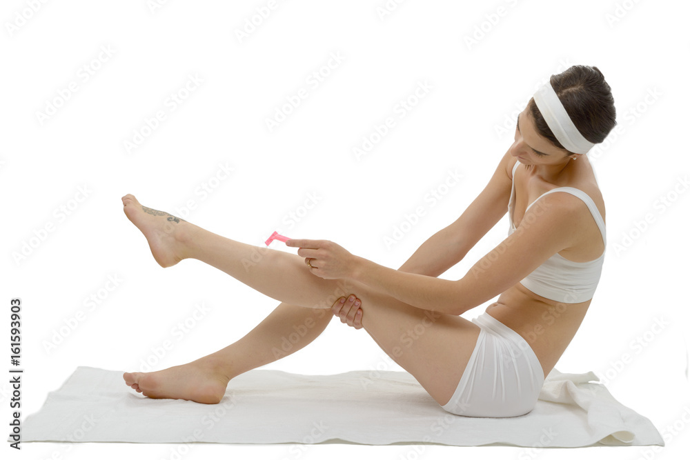Fototapeta premium beautiful adult caucasian woman shaving legs with razor