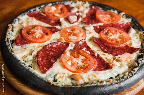 Delicious pizza with meat, cheese and mushrooms