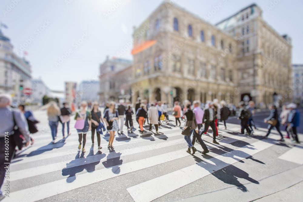 Crowd of anonymous people walking on busy city street