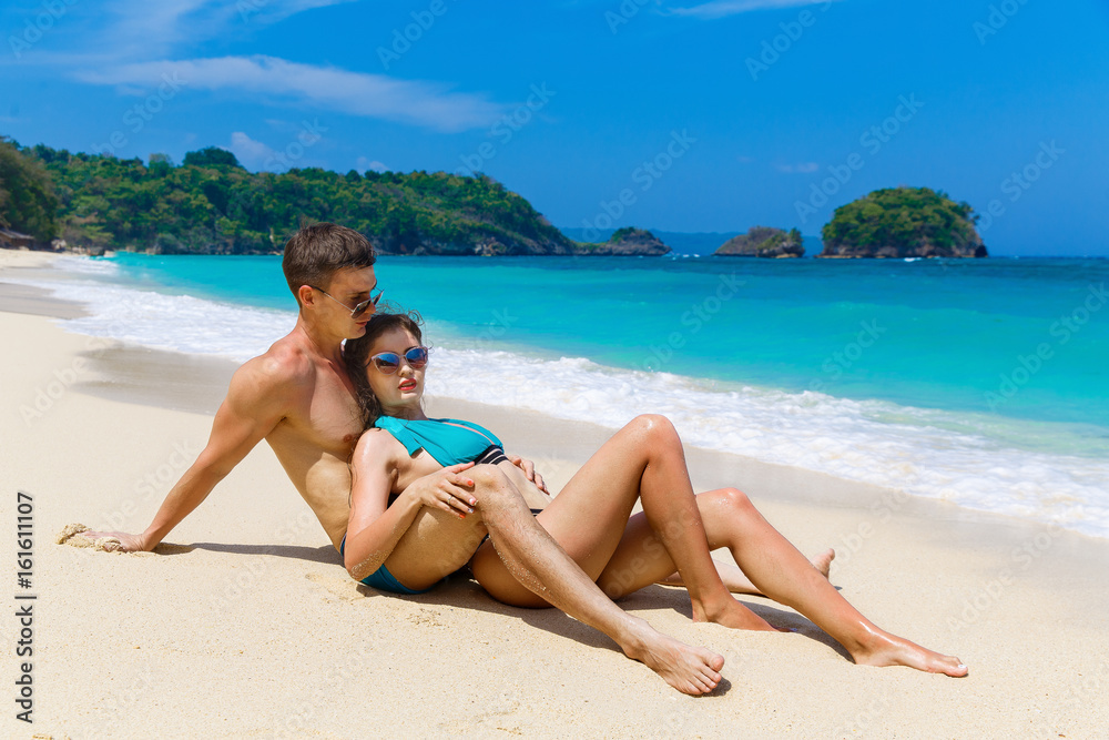 Young loving couple having fun on tropical beach. Summer vacation concept. Young loving couple having fun on tropical beach. Summer vacation concept.