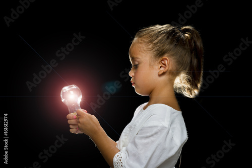 girl holding a light bulb lit up looking at it