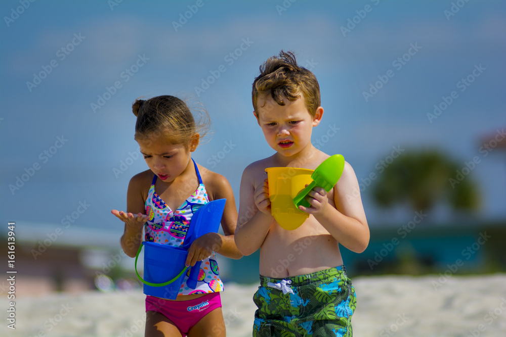Φωτογραφία young girl and bot at the beach by the water playing togather in swim suits