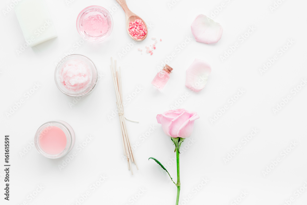 homemade spa with rose cosmetic set, cream, salt and oil on white background top view