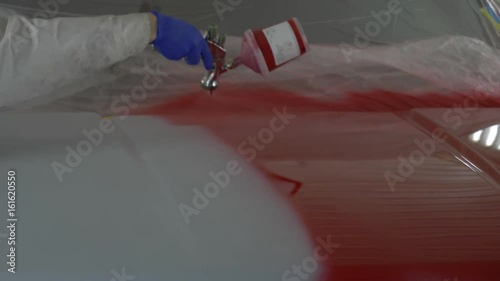 Applying a coat of red car paint 