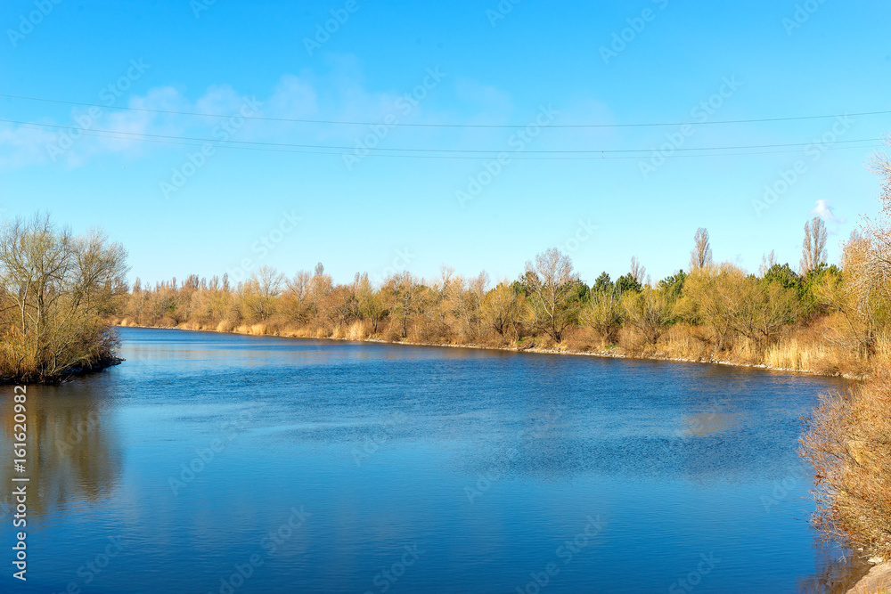 Spring comes to the river bank. Power lines above the channels. Spring comes to the river bank. Power lines above the channels.