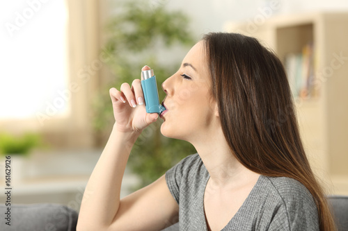 Asthmatic woman using an inhaler