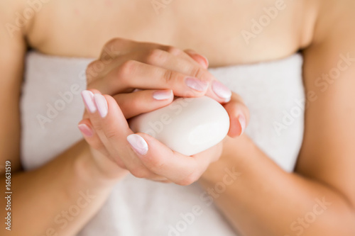 Young woman in towel with soap in hands. Skin care.