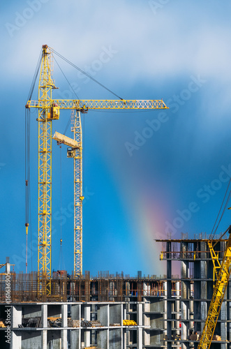 Cranes building industrial sky rain rainbow.