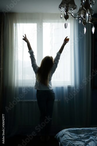 Morning girl hands up, standing back, near the window, bedroom © Елена Кравчук