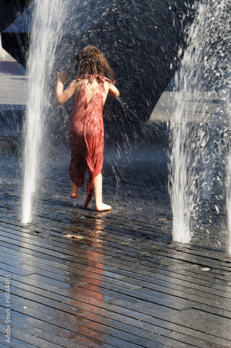 Fototapeta Naklejka Na Ścianę i Meble -  Child playing in a fountain with water 