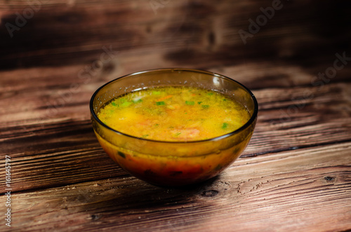 Vegetable soup in a glass bowl on wooden table