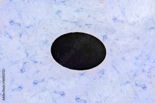 Blue background of marble and black oval in the middle for text