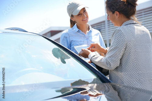 Obraz na plátně Woman in parking lot renting car from rental company