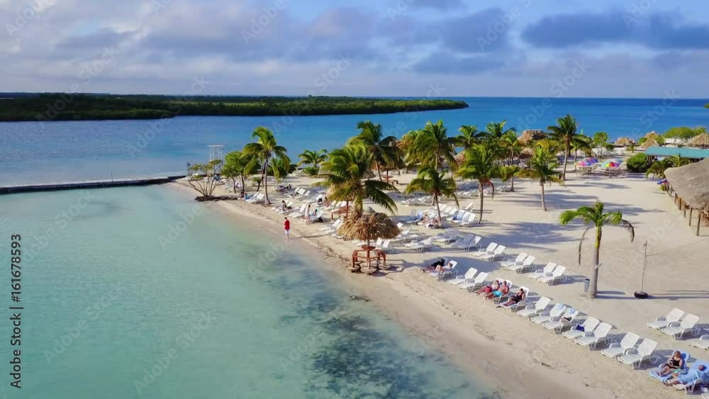 A quick circular drone flight over an island. Capturing spectacular views of gorgeous waters, lounging tourist, and the different amenities A quick circular drone flight over an island. Capturing spectacular views of gorgeous waters, lounging tourist, and the different amenities