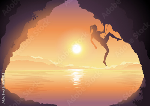 Woman climbing on a cliff, beautiful sunset