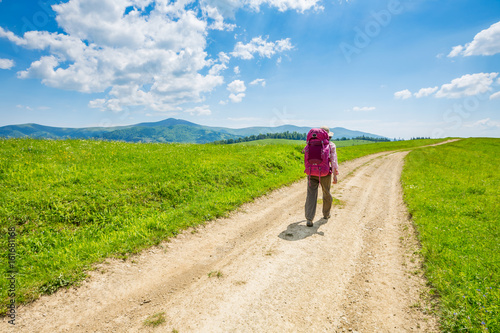 A woman with backpack and road.