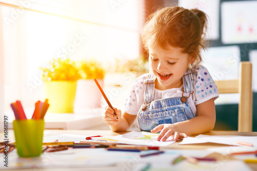 Canvas Print child  girl draws with colored pencils