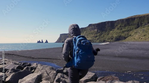 Woman exploring beautiful Reynisfjara beach near Vik, Icealnd photo